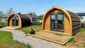 Deux cabanes en bois de style « capsule », dotées de portes en verre et d’un petit espace porche.