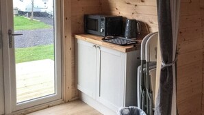 Une cuisine compacte équipée d’un four à micro-ondes, d’un grille-pain et d’un réfrigérateur.