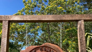 Un senyal de fusta amb un disseny de bússola i el text 'Lost Compass Cabanas' muntat sobre una estructura metàl·lica.
