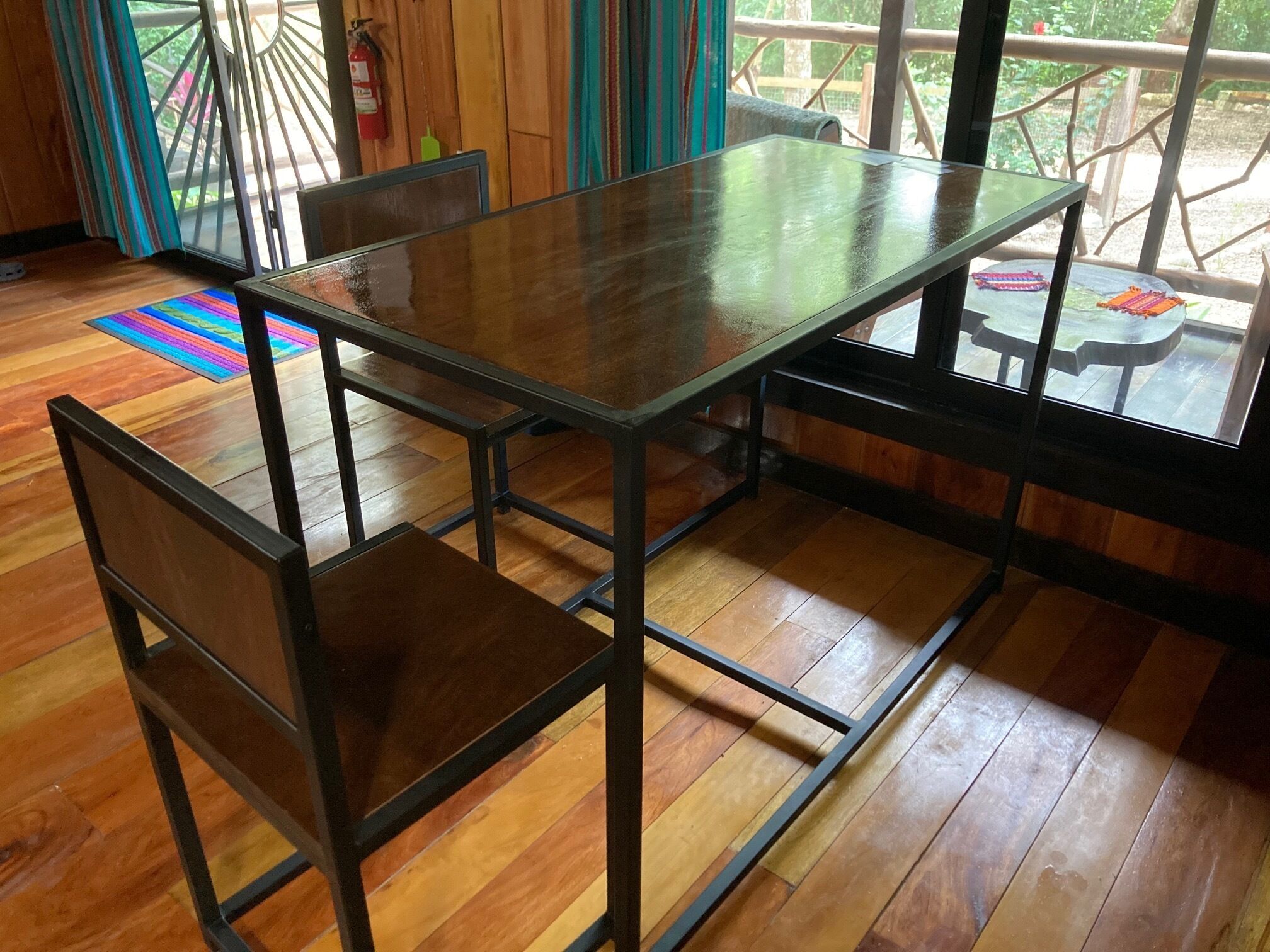 A dining area with a glass-top table and metal frame chairs.
