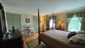 A four-poster bed with a floral bedspread, a wooden dresser, a chair, and a window with curtains. - Relax at The Farmhouse at Kindred Ground (Avon)