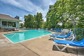 Ein Pool mit Liegestühlen und einer überdachten Sitzgruppe.