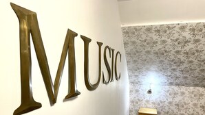 A room with a wall-mounted sign spelling "MUSIC" in large letters. - Appartement Type Loft en Pleine Nature (Rumigny)