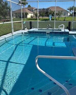 A swimming pool with clear blue water, surrounded by a white fence, and houses in the background. - No Cleaning Fee!
Luxury Villa Awaits! Close to Disney and New Attractions! (Davenport)