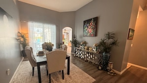 Un espace repas comprenant une table, des chaises et une composition florale décorative.