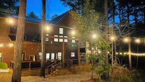 A rustic wooden building with a balcony, surrounded by trees. - Stunning Farmhouse 1 mile to new casino sleeps 10 Hot Tub (Broken Bow)
