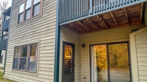 A two-story house with a covered porch and a sliding glass door.