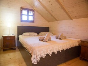 Cozy cabin retreat with a large bed, floral-patterned duvet, and a functional workspace.