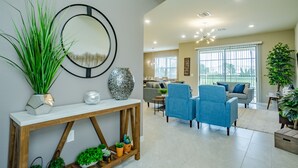 A modern living room with a sofa, chairs, a coffee table, and a console table with decorative items.