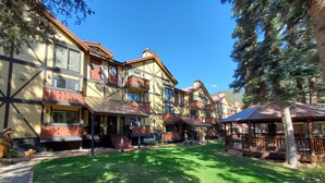 A traditional chalet-style building with multiple balconies and a covered patio area. - Auslander Condominiums (Red River)
