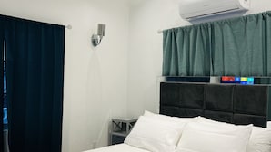 Et moderne hotelværelse med en stor seng, indbygget klimaanlæg, et sengebord og et natbord.
