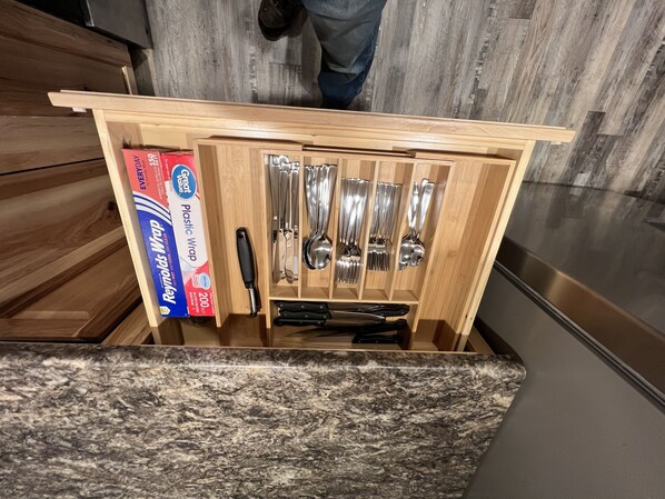 Eine Schublade mit Küchenutensilien und einer Frischhaltebox.