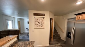A modern kitchen with a granite countertop, stainless steel refrigerator, and a wooden dining table. - New cute clean 4plex w/game rm, centrally located between North Pole & Fairbanks (Fairbanks)