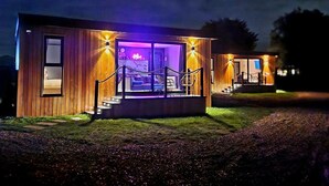 A modern wooden cabin with a balcony and a staircase leading to the entrance. - TT Lodges (Stockton-on-Tees)
