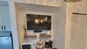 A compact kitchen with a built-in microwave, a coffee maker, and a small cabinet. - Romantic Escape on Peaceful Mini Farm (Coleman)