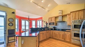 Una cocina moderna con armarios de madera, electrodomésticos de acero inoxidable y una isla central.