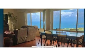 Relax in this ocean-view living area with a large table, comfortable sofa, and scenic views.
