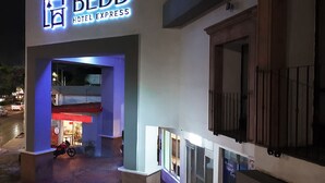 The exterior of the BEDD Hotel Express with a neon sign, a motorcycle parked outside, and a gated entrance. - Hotel Bedd Express Querétaro (Querétaro)