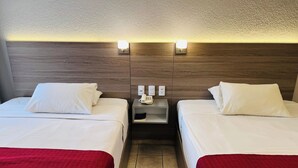 A hotel room with two beds, a nightstand with a phone, and a wall-mounted light fixture. - Hotel Bedd Express Querétaro (Querétaro)