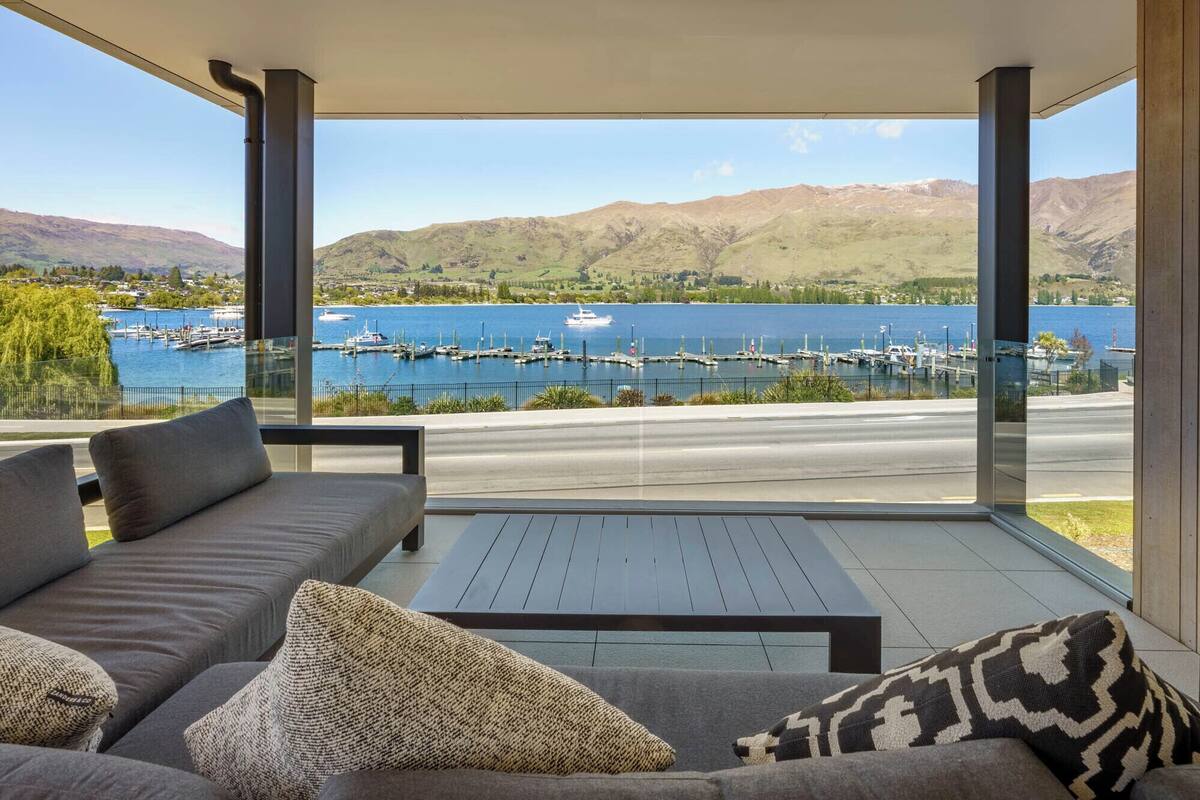 A modern room with a large window overlooking a marina and hills.