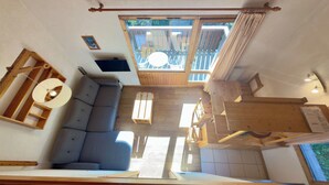 A spacious room with a built-in wooden bench, a sofa, and a dining table.