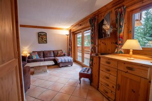 A cozy room with a wooden interior, a sofa, a bench, and a wooden cabinet with drawers. - Krystor 4 in the center of Meribel (Les Allues)