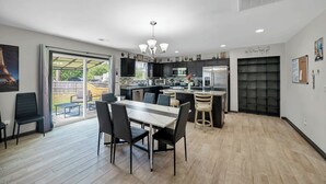 A modern kitchen with a dining area, large windows, and a view of the outdoors. - Home away from Home (Lexington)