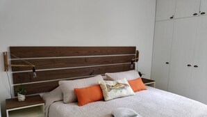 A neatly made bed with a patterned bedspread, two pillows, and a folded towel on the bed. - Cozy 2BR Apt, 50 meters from the beach with large pool (Progreso)