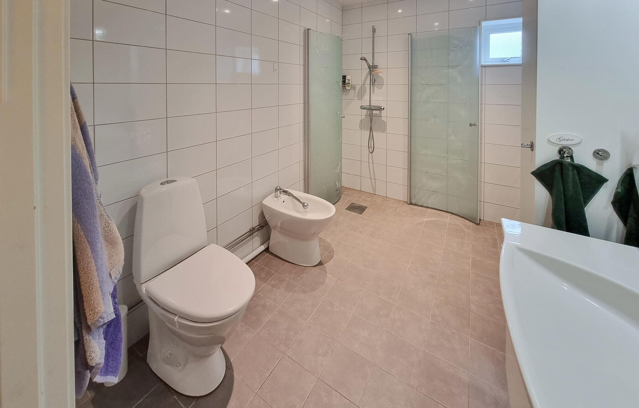 A modern bathroom with a toilet, bidet, and shower.
