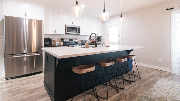 A modern kitchen with stainless steel appliances, a large island with bar stools, and pendant lighting. - NEW! Near ASU/Spring Training/Old Town Scottsdale! (Tempe)