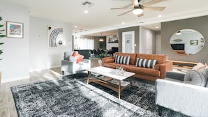 A modern living room with a white sofa, a brown leather sofa, and a grey armchair. There is a coffee table in the center, and a ceiling fan above. - NEW! Near ASU/Spring Training/Old Town Scottsdale! (Tempe)