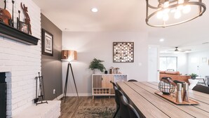 A dining area with a wooden table, chairs, a chandelier, a fireplace, and a decorative plant. - NEW! Near ASU/Spring Training/Old Town Scottsdale! (Tempe)
