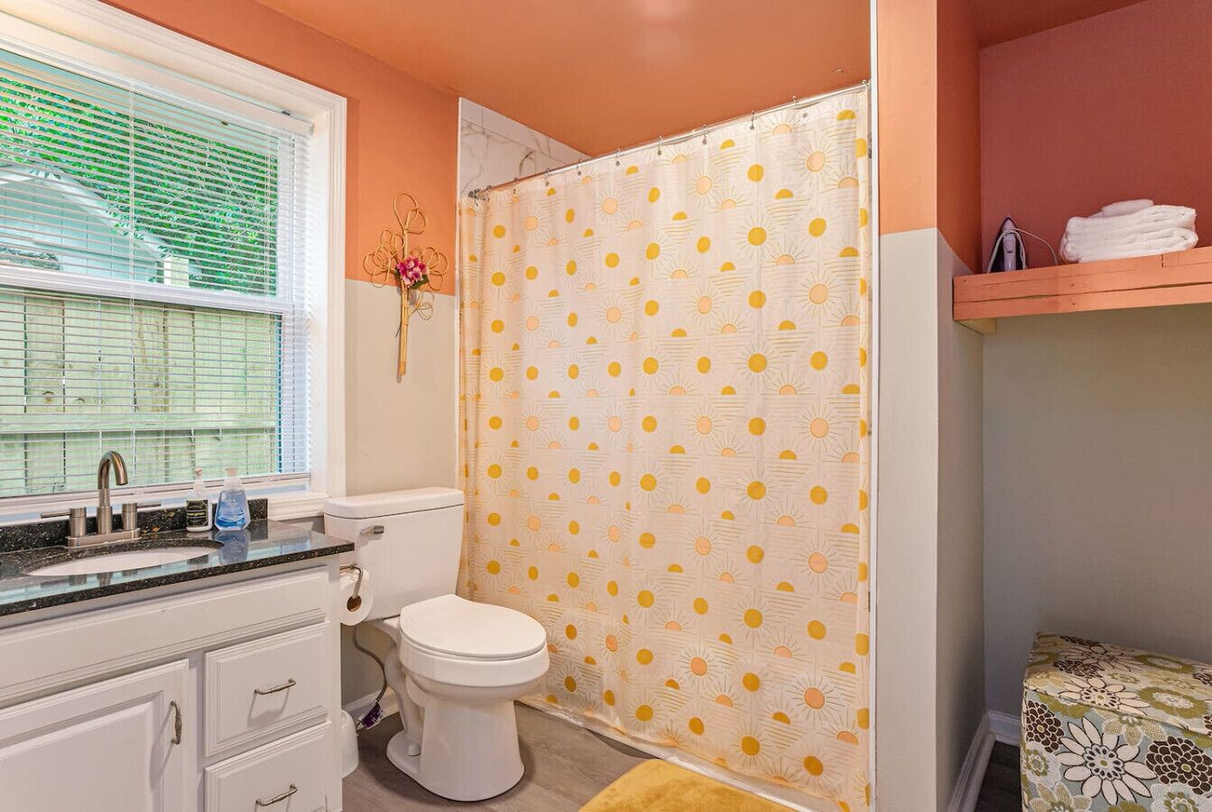 Une salle de bain avec des toilettes, un lavabo et un rideau de douche.