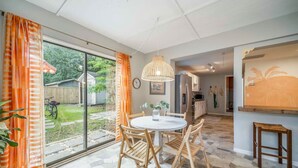 Una cucina moderna con zona pranzo, ampie finestre e vista sul giardino.