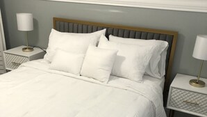 Una cama bien hecha con cabecera de madera, ropa de cama blanca y dos mesitas de noche con lámparas.