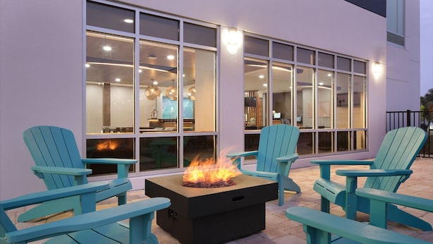 Un espace patio agrémenté d’un foyer et de fauteuils Adirondack.