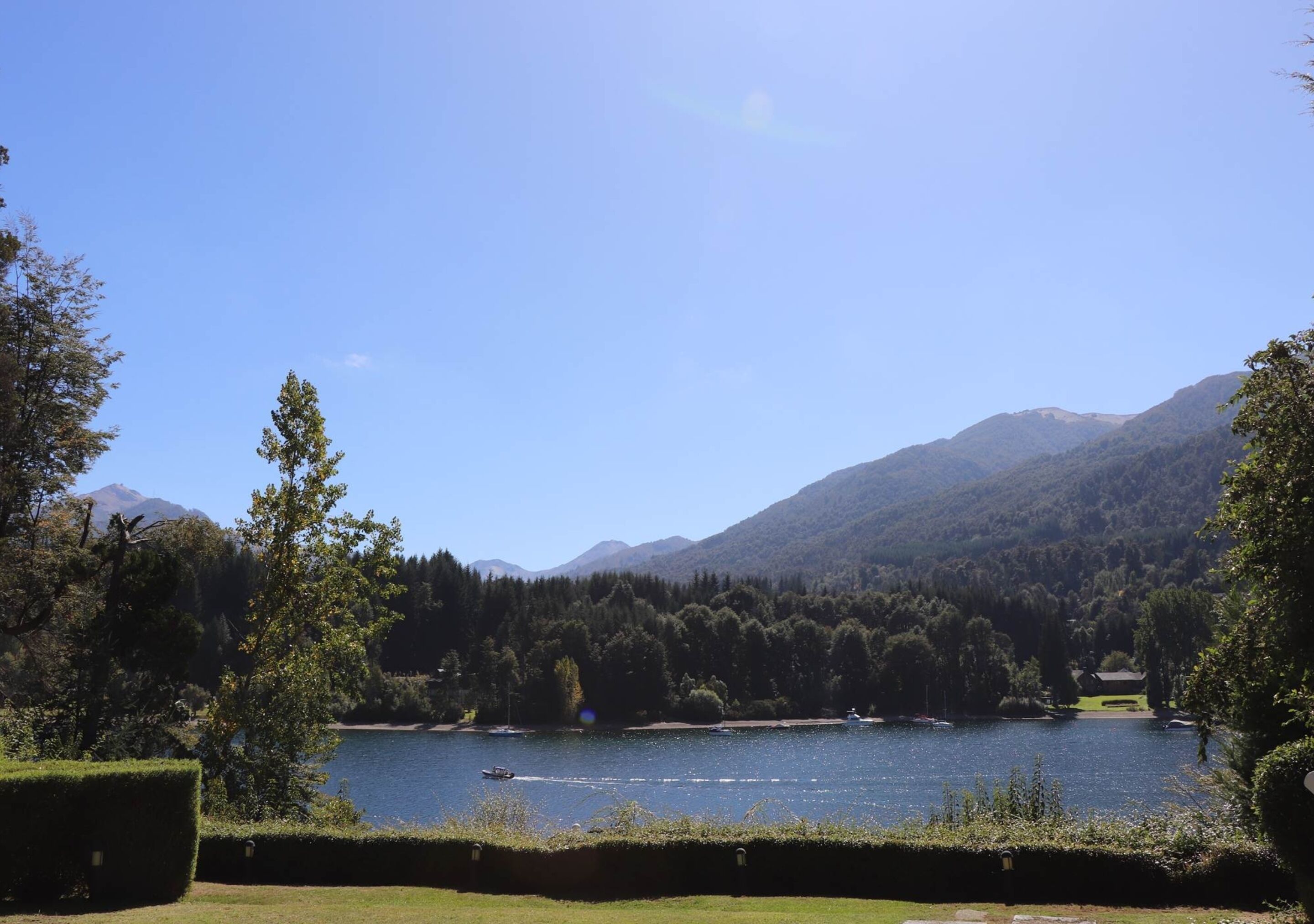 A serene lake surrounded by mountains and dense forests.