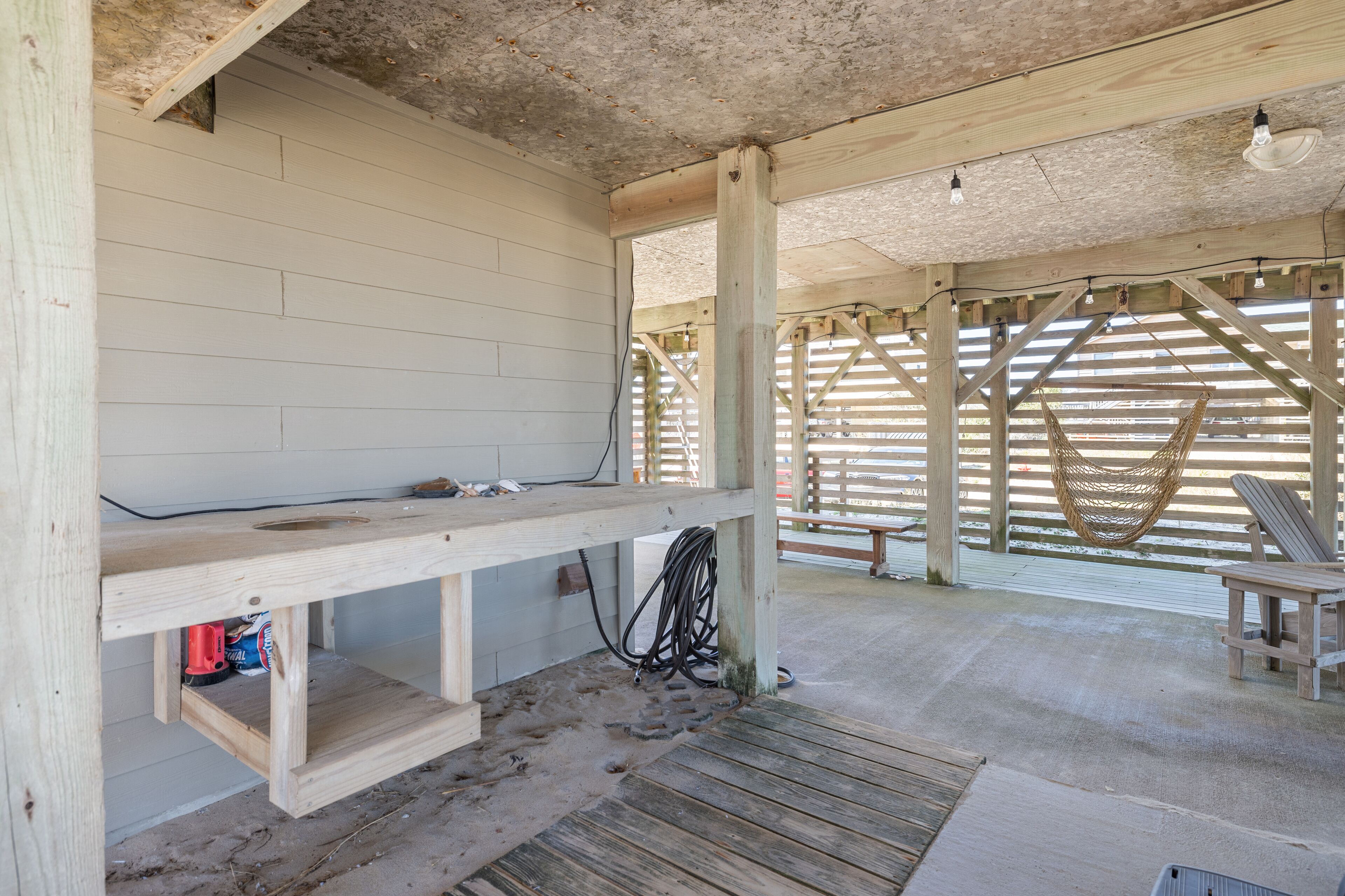 Ein Holzinterieur mit einer Bank, einem Hängekorbsessel und einem Holztisch.