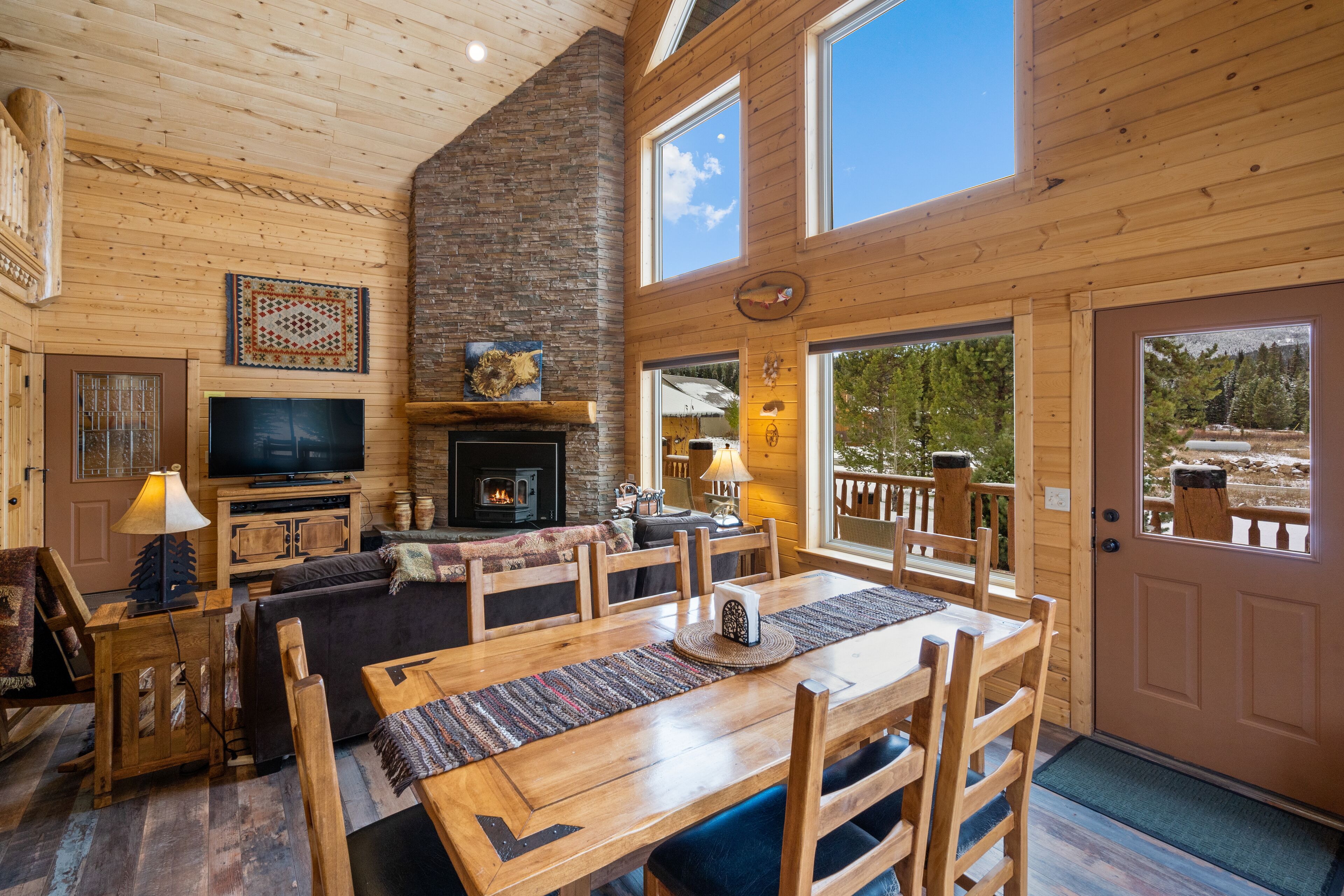 A wooden interior with a fireplace, television, and dining area.