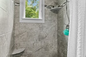 Enjoy a refreshing shower with a view of lush greenery outside.