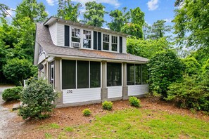 Enjoy a serene and stay surrounded by lush greenery and trees on this two-story house's shaded outdoor space.