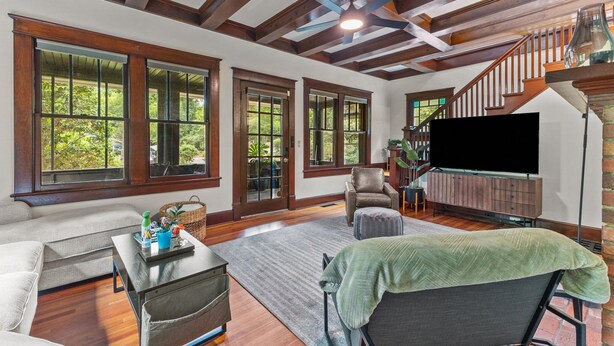 A spacious living room with large windows, a fireplace, and a TV. - Historic Hidden Gem - Downtown Southern Pines (Southern Pines)