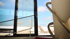 Ein modernes Interieur mit einem großen Fenster, einer Wendeltreppe und einer Decke mit strahlenförmigen Balken.
