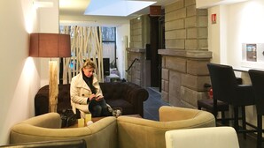 Ein modernes Interieur mit einer Couch, einem Tisch mit Kerzen und einem Kamin.