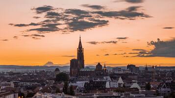Une vue urbaine avec une cathédrale imposante, prise au coucher du soleil.