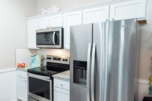 Una cocina moderna con electrodomésticos de acero inoxidable, incluyendo un microondas, horno y refrigerador.