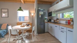 A compact kitchen with white cabinets, a stainless steel refrigerator, and a wooden countertop. - Cozy Home in Rudzienice (Rudzienice)