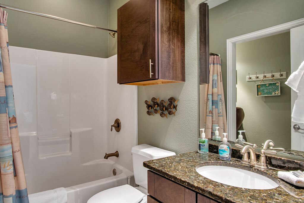 A bathroom with a bathtub, toilet, and sink.