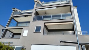 Un edificio a più piani con balconi, ampie finestre e tetto piano.