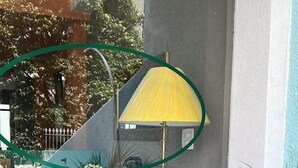 A balcony with a yellow umbrella, potted plants, and a metal spiral staircase. - Vicz Palace Hotel (Curitiba)